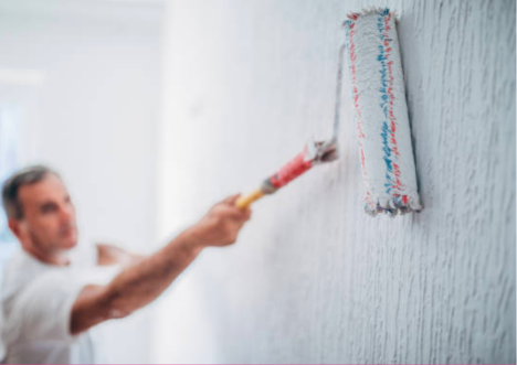 professional painter using a roller to paint a wall white