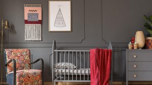 nursery with gray crib, dresser, and wall