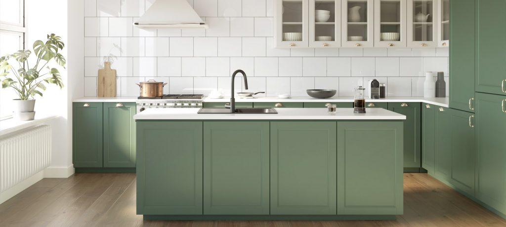 A kitchen with sage-green painted cabinets and island under a white countertop