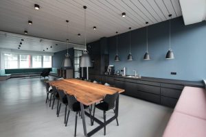 kitchen area inside of an office with dark cabinets and blue painted walls