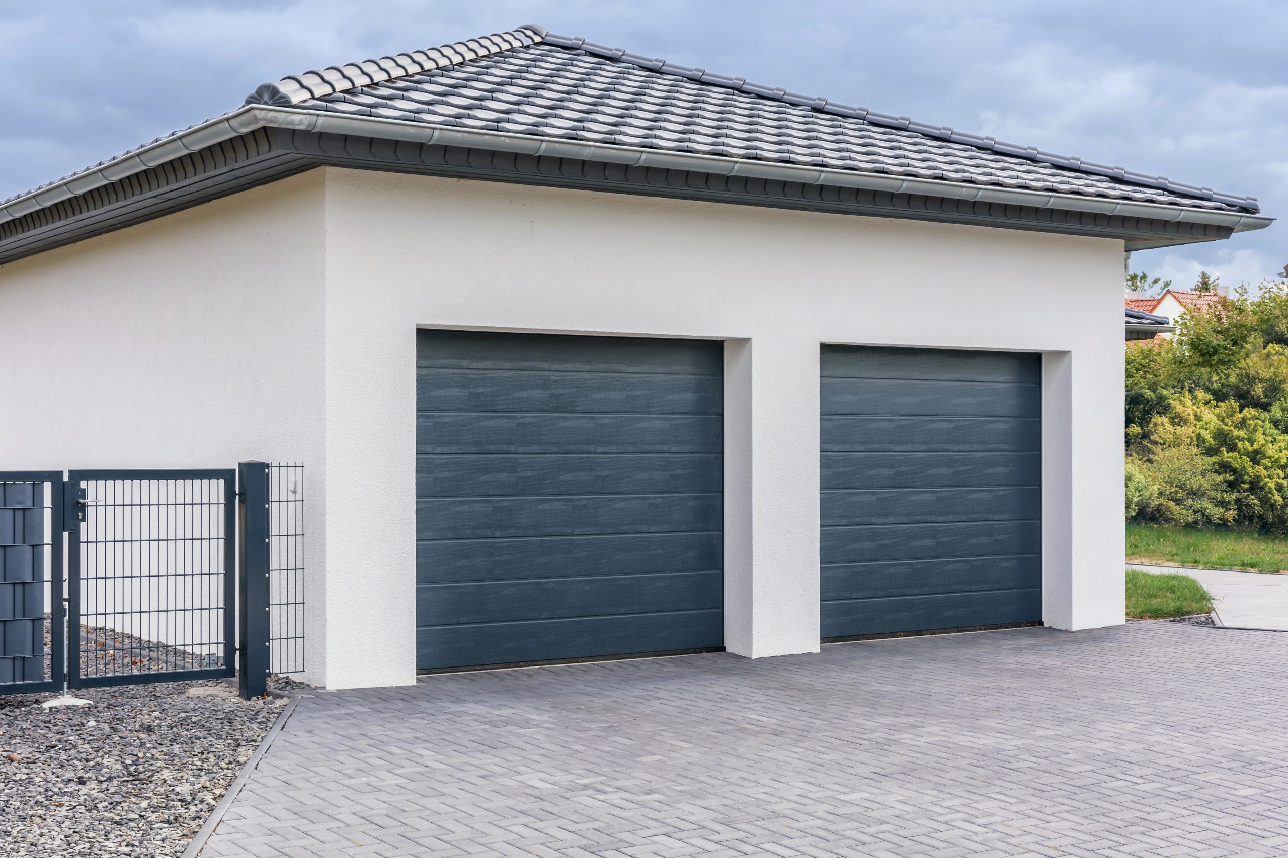 garage at a home with two green painted doors and matching fence