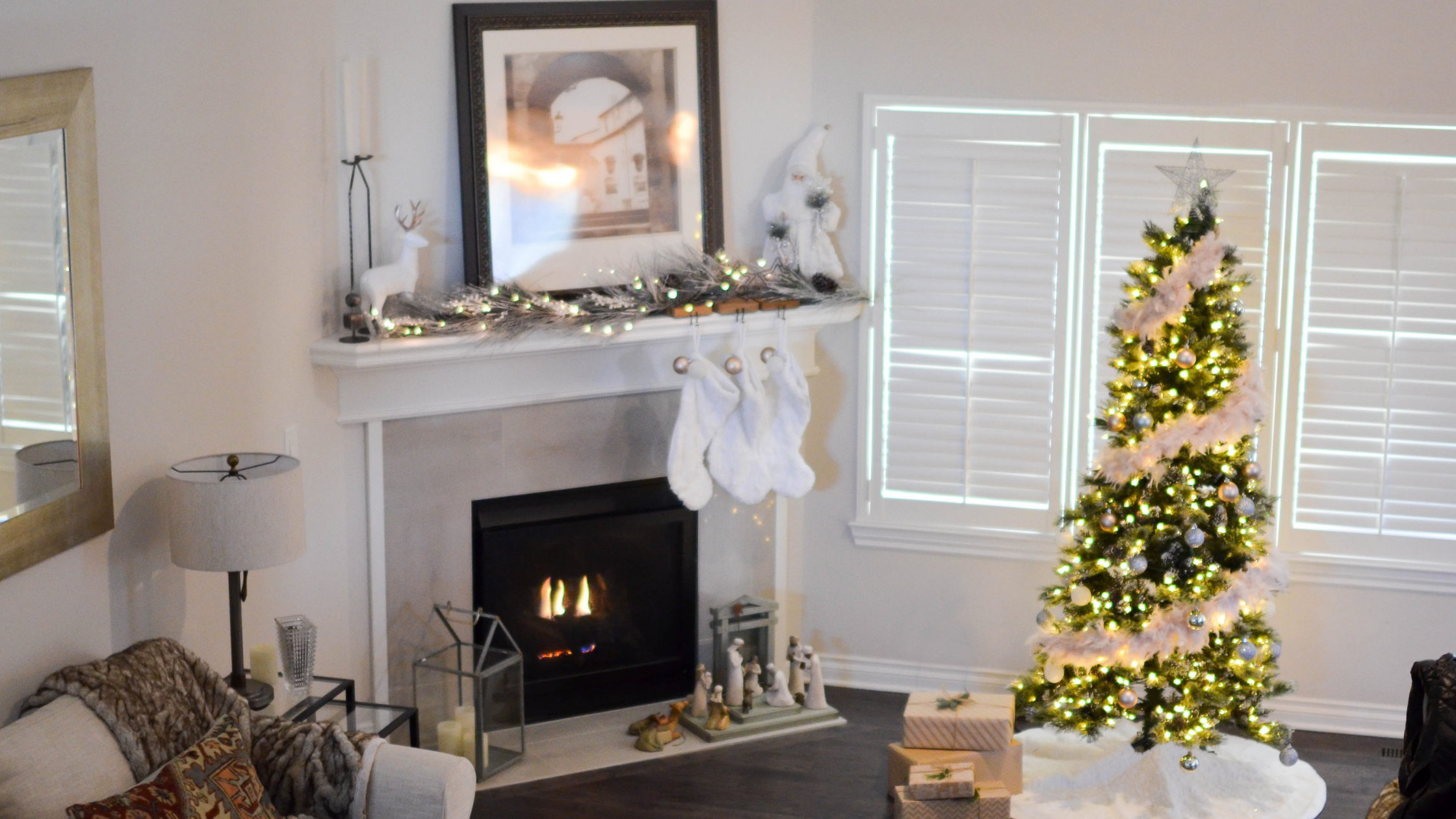 living room in a home decorated for Christmas with a tree and stockings hanging above the fireplace